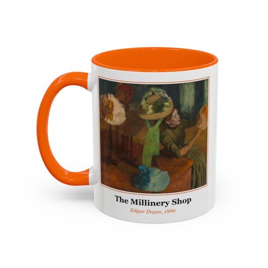 #77 The Millinery Shop mug — the framed painting with its title and artist beneath, as seen from across the table
